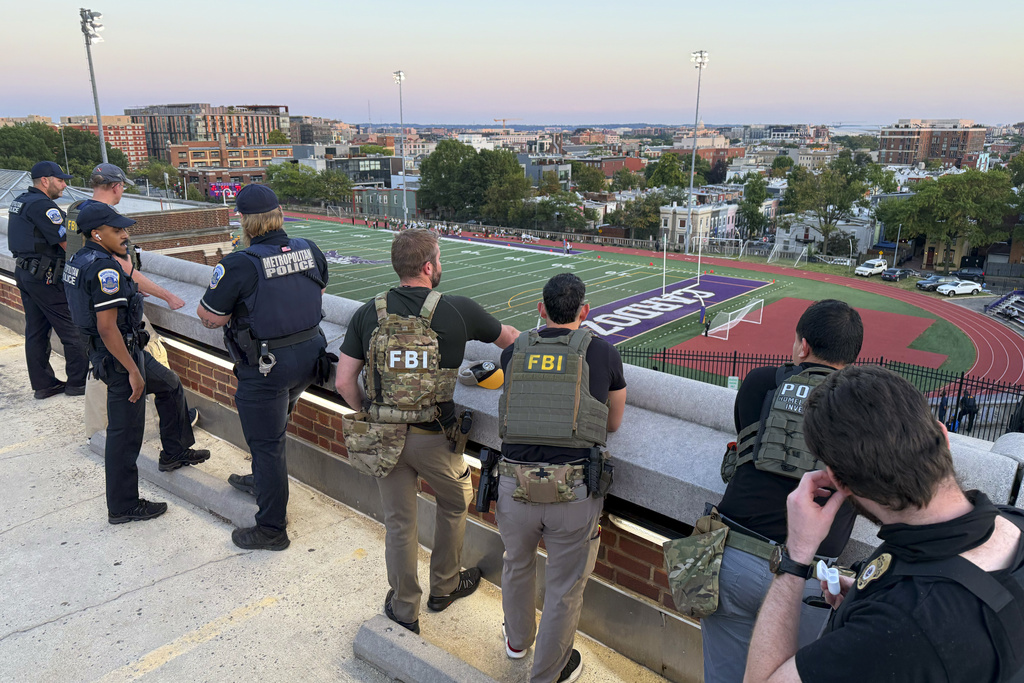 Officers from Metropolitan Police Department, FBI, and Homeland Security Investigations (HSI), are seen monitoring a football game between Bell Multicultural and Archbishop Carroll, Friday, Sept., 12, 2025, at Cardozo High School in the Columbia Heights neighborhood in Washington. (AP Photo/Pablo Martinez Monsivais)