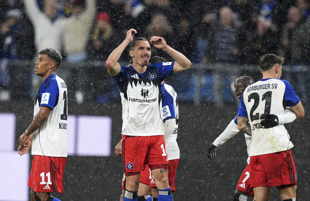 Hamburger's Rayan Philippe, center, celebrates scoring during the Bundesliga soccer match between Hamburger SV and FSV Mainz 05 at the Volksparkstadion, Hamburg, Germany, Sunday Oct. 5, 2025. (Marcus Brandt/dpa via AP)
