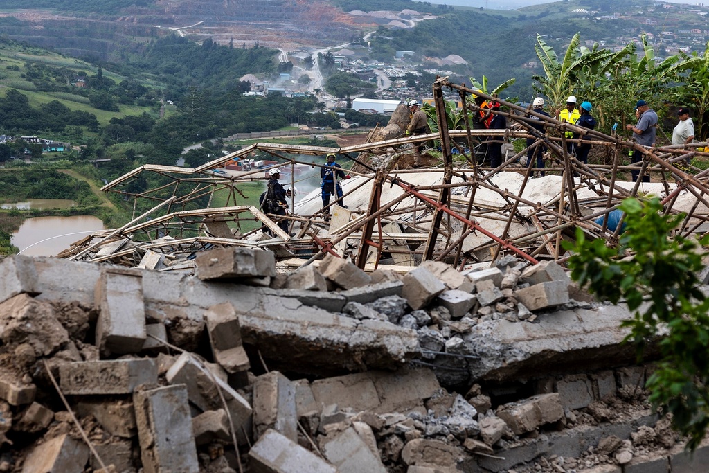 Rescuers search for victims after a multi-story building that was under construction collapsed on a temple below it, near the town of Verulam, north of the east coast city of Durban, South Africa, Friday, Dec. 12, 2025. (AP Photo)