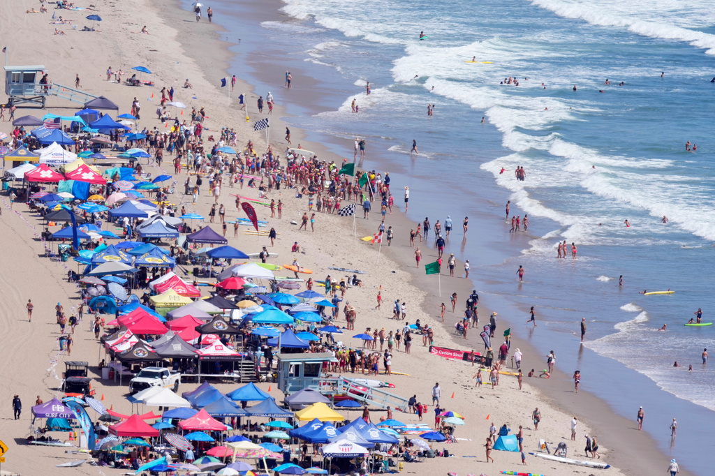 Beach goers watch during the the 46th Annual California Surf Lifesaving Championships on Will Rogers State Beach Friday, July 24, 2026, in the Pacific Palisades section of Los Angeles. (AP Photo/Mark J. Terrill)