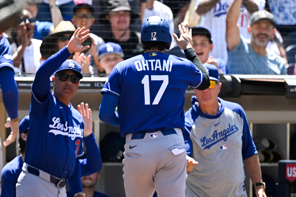 Los Angeles Dodgers designated hitter Shohei Ohtani (17) is welcomed into the dugout after scoring during the fifth inning of a baseball game against the San Diego Padres, Sunday, June 28, 2026, in San Diego. (AP Photo/Denis Poroy)