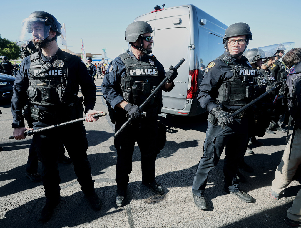 Officers from the Tucson Police Department stand along Grande Avenue after protesters clashed with Homeland Security Investigations Special Response Team in Tucson, Ariz., Friday, Dec. 5, 2025. (Mamta Popat /Arizona Daily Star via AP)