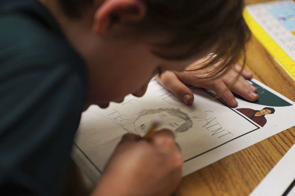 Alex Miller, a fifth-grade student at St. John Berchmans' school draws a picture of Blessed Carlo Acutis, who will be canonized a saint by Pope Leo XIV, during a class activity on Wednesday, Sept. 3, 2025, in Chicago. (AP Photo/Jessie Wardarski)
