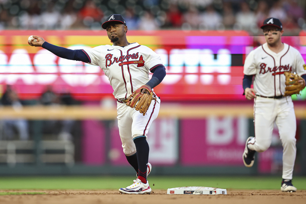 Atlanta Braves second baseman Ozzie Albies, left, throws to first base in the second inning of a baseball game against the Chicago White Sox, Monday, Aug. 18, 2025, in Atlanta. (AP Photo/Colin Hubbard)