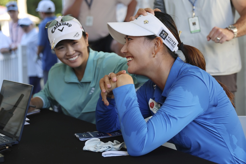Rose Zhang, left, jokes with Miranda Wang, right, of China, at the scorer's table after Wang won the FM Championship LPGA golf tournament at TPC Boston, Sunday, Aug. 31, 2025, in Norton, Mass. (AP Photo/Michael Dwyer)