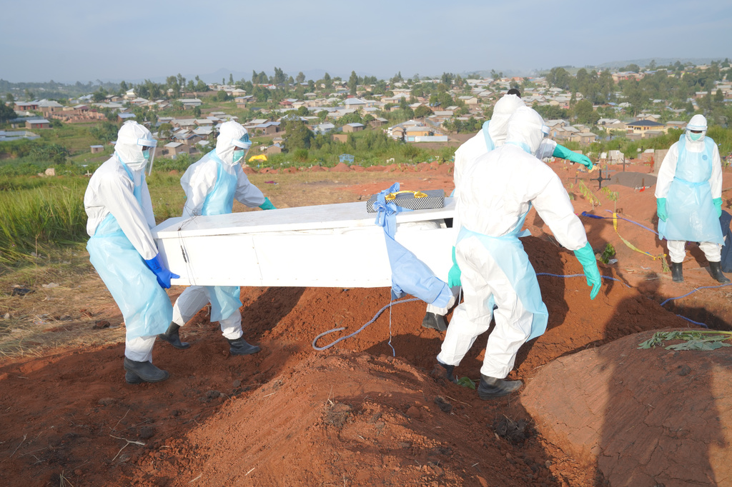 People dressed in protective gear carry the coffin that contain the remains of Jacques Lobo Dhena, who died of Ebola, during a burial service in Bunia, Ituri province, eastern Congo, Wednesday, Aug. 12, 2026. (AP Photo/Dieudonne Dirole)