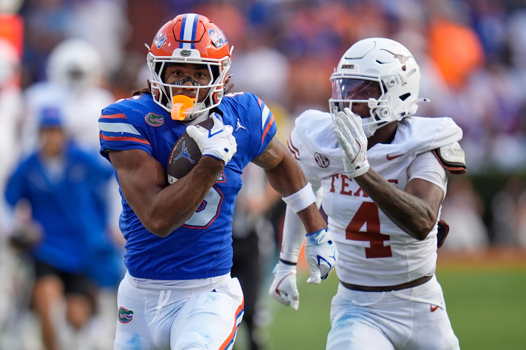 FILE - Florida wide receiver Dallas Wilson, left, outruns Texas defensive back Jelani McDonald to score a touchdown during the second half of an NCAA college football game, Oct. 4, 2025, in Gainesville, Fla. (AP Photo/John Raoux, File)