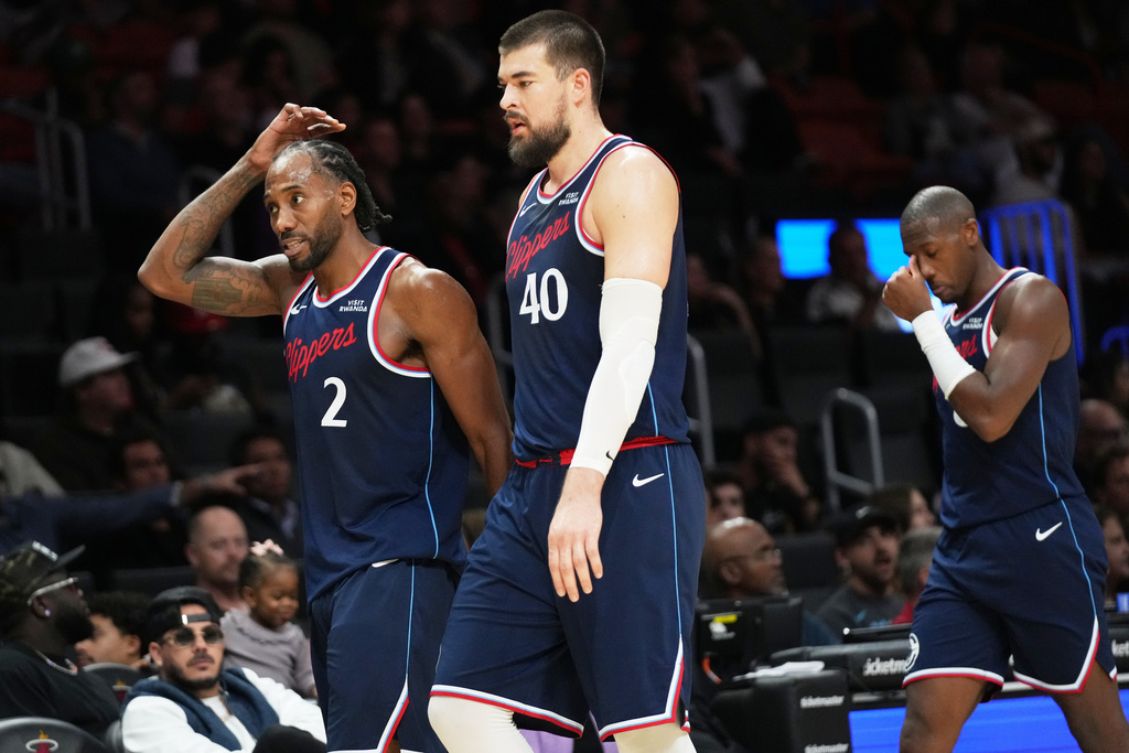 Los Angeles Clippers forward Kawhi Leonard (2), center Ivica Zubac (40) and guard Kris Dunn, right, walk off the court after being substituted during the second half of an NBA basketball game against the Miami Heat, Monday, Dec. 1, 2025, in Miami. (AP Photo/Lynne Sladky)