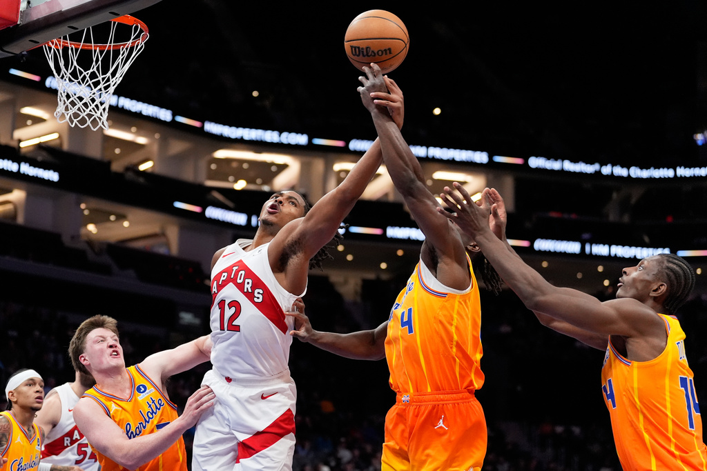 Toronto Raptors forward Collin Murray-Boyles is found by Charlotte Hornets guard Sion James during the first half of an NBA basketball game, Saturday, Nov. 29, 2025, in Charlotte, N.C. (AP Photo/Chris Carlson)