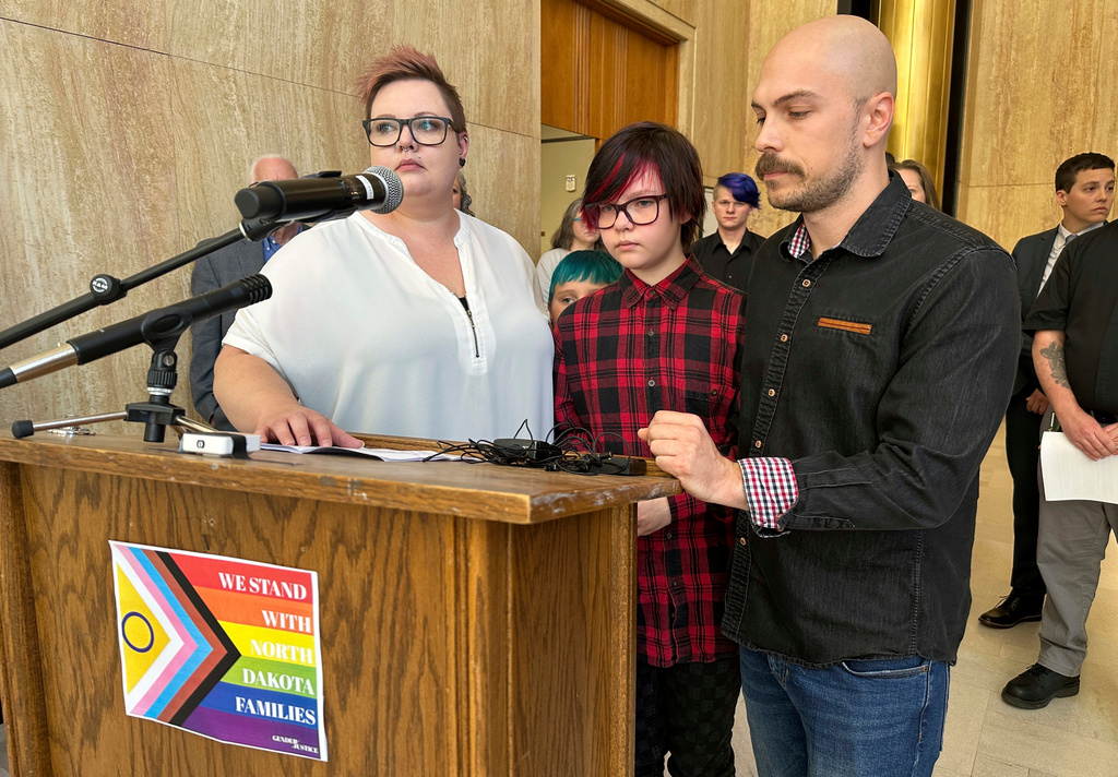 FILE - Parents Devon and Robert Dolney, stand with their child, Tate, center, during a news conference, Sept. 14, 2023, at the state Capitol in Bismarck, N.D. (AP Photo/Jack Dura, File)