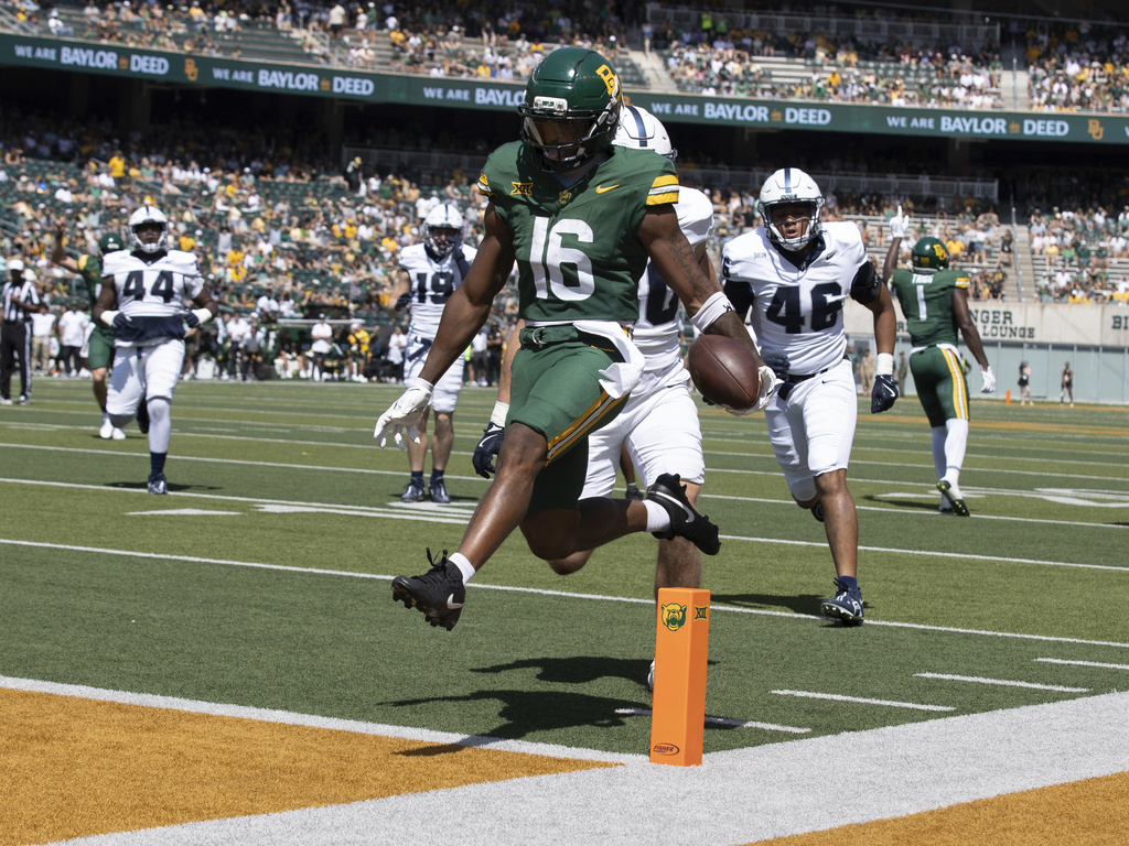 Baylor's wide receiver Kobe Prentice high steps it into the end zone past Samford's linebacker Carson Sloan for a touchdown in the first half of an NCAA college football game, Saturday, Sept. 13, 2025, in Waco, Texas. (Jerry Larson/Waco Tribune-Herald via AP)