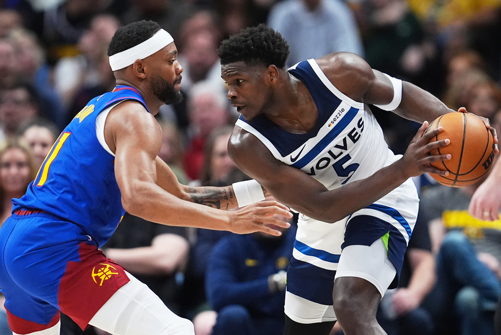 Minnesota Timberwolves guard Anthony Edwards, right, looks to move to the rim as Denver Nuggets guard Bruce Brown defends in the first half of an NBA basketball game, Sunday, March 1, 2026, in Denver. (AP Photo/David Zalubowski)