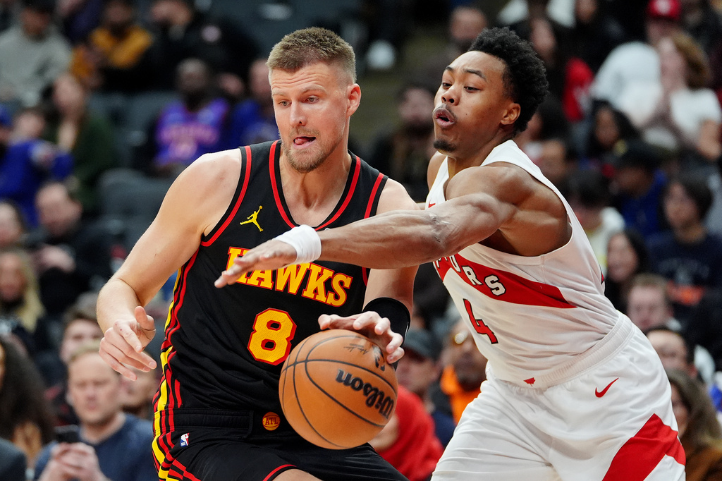 Toronto Raptors forward Scottie Barnes (4) tries to strip the ball from Atlanta Hawks centre Kristaps Porzingis (8) during second half NBA basketball action in Toronto, Monday, Jan. 5, 2026. (Frank Gunn/The Canadian Press via AP)
