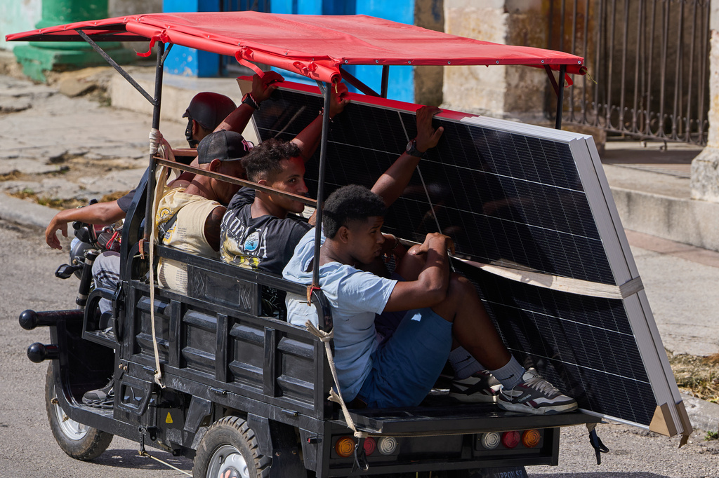 People transport solar panels on an electric tricycle in Havana, Cuba, Friday, July 10, 2026. (AP Photo/Ramon Espinosa)