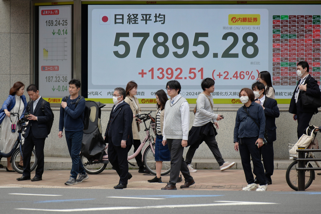 People walk in front of an electronic stock board showing Japan's Nikkei index at a securities firm Tuesday, April 14, 2026, in Tokyo. (AP Photo/Eugene Hoshiko)