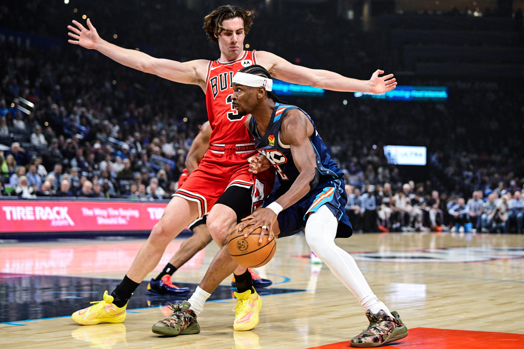 Oklahoma City Thunder guard Shai Gilgeous-Alexander (2) drives against Chicago Bulls guard Josh Giddey (3) during the first half of an NBA basketball game Friday, March. 27, 2026, in Oklahoma City. (AP Photo/Gerald Leong)