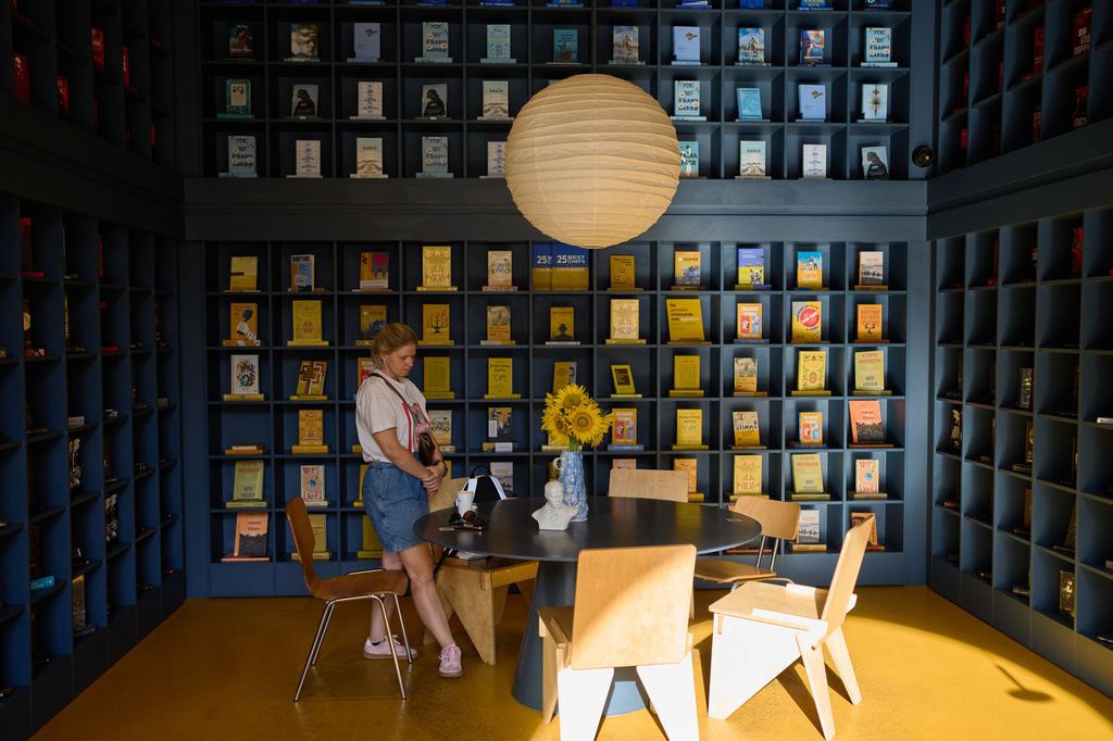 A woman observes a daily nationwide minute of silence in memory of soldiers killed in the war with Russia at a book store in Kyiv, Ukraine Wednesday, Sept. 2, 2026. (AP Photo/Francisco Seco)