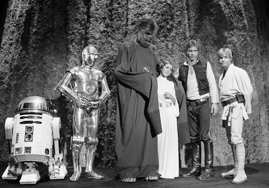 FILE - Kenny Baker, from left, Anthony Daniels, Peter Mayhew, Carrie Fisher, Harrison Ford and Mark Hamill are seen during the filming of the CBS-TV special, "The Star Wars Holiday," in Los Angeles, Nov. 13, 1978. (AP Photo/George Brich, File)