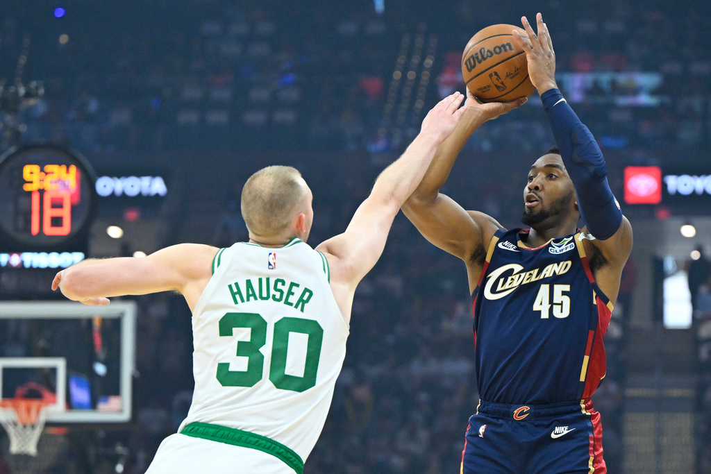 Cleveland Cavaliers guard Donovan Mitchell (45) shoots beside Boston Celtics forward Sam Hauser (30) in the first half of an NBA basketball game in Cleveland, Sunday, March 8, 2026. (AP Photo/David Richard)