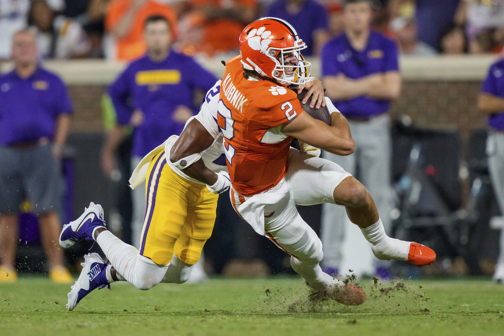 LSU safety Jardin Gilbert tackles Clemson quarterback Cade Klubnik (2) in the first half of an NCAA college football game, Saturday, Aug. 30, 2025, in Clemson, S.C. (AP Photo/Jacob Kupferman)