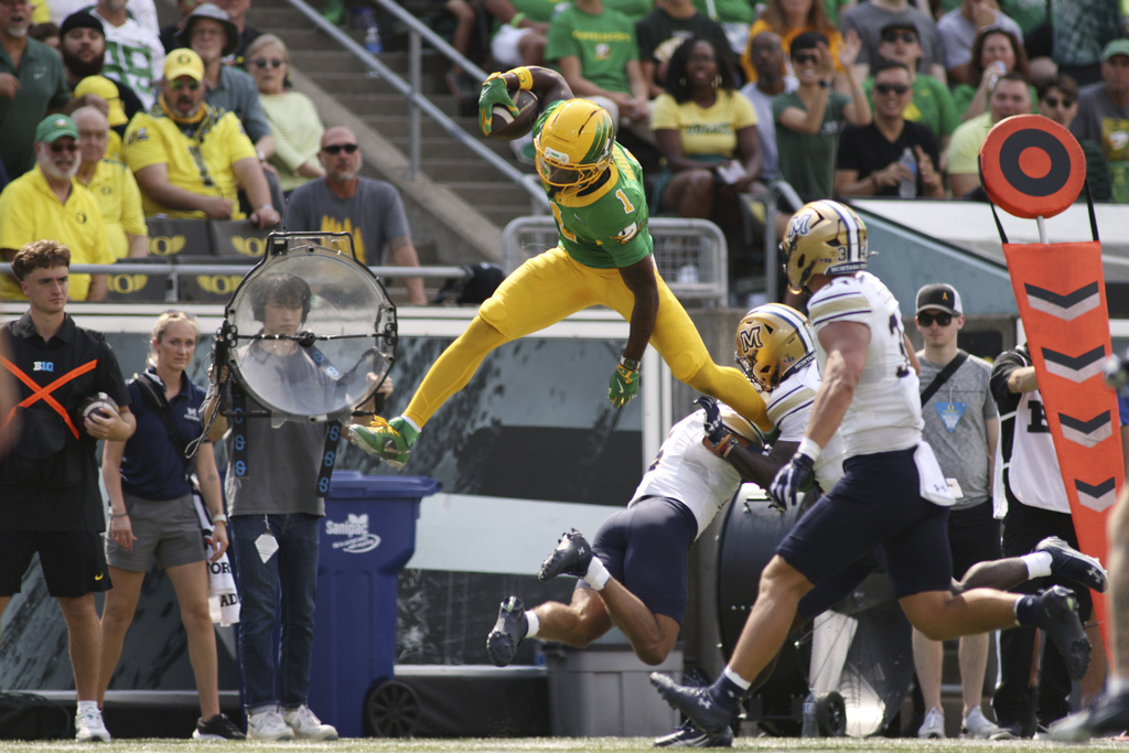 Oregon wide receiver Dakorien Moore (1) jumps over a Montana State player during the first half of an NCAA college football game, Saturday, Aug. 30, 2025, in Eugene, Ore. (AP Photo/Lydia Ely)