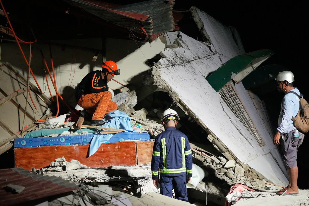 Rescuers check for survivors in the ruins of a collapsed building, Wednesday, Oct. 1, 2025 after a strong earthquake struck Bogo city, Cebu Province, Central Philippines. (AP Photo/Aaron Favila)