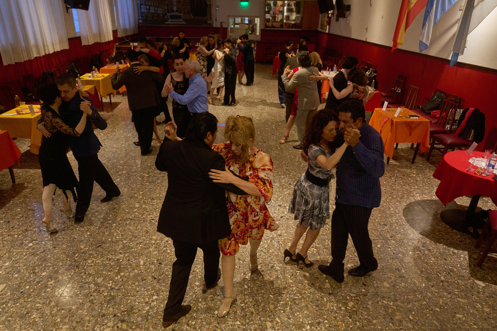 Beth Wolff, of German-Argentine, front right, dances with a professional tango dancer at the Che Che Tango Premium, where people can book guaranteed two‑hour dances with professional partners known as “Taxi Dancers," in Buenos Aires, Wednesday, Dec. 3, 2025. (AP Photo/Victor R. Caivano)