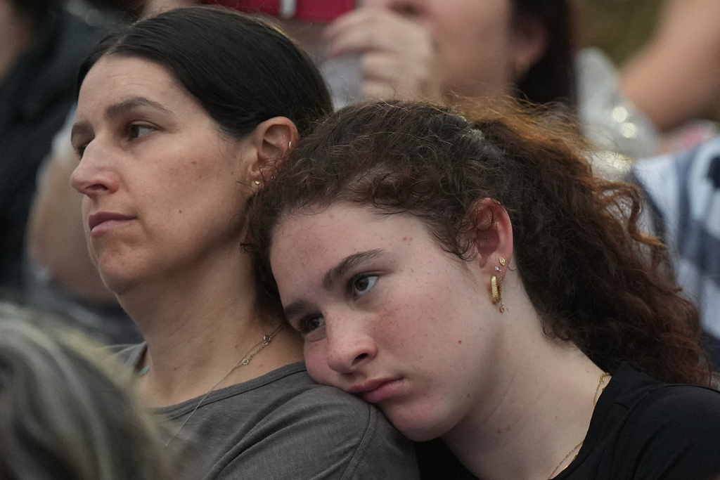 People attend a ceremony to mark the National Day of Reflection for victims and survivors, at Bondi Beach in Sydney, Sunday, Dec. 21, 2025, following the Bondi shooting on Dec. 14. (AP Photo/Mark Baker)