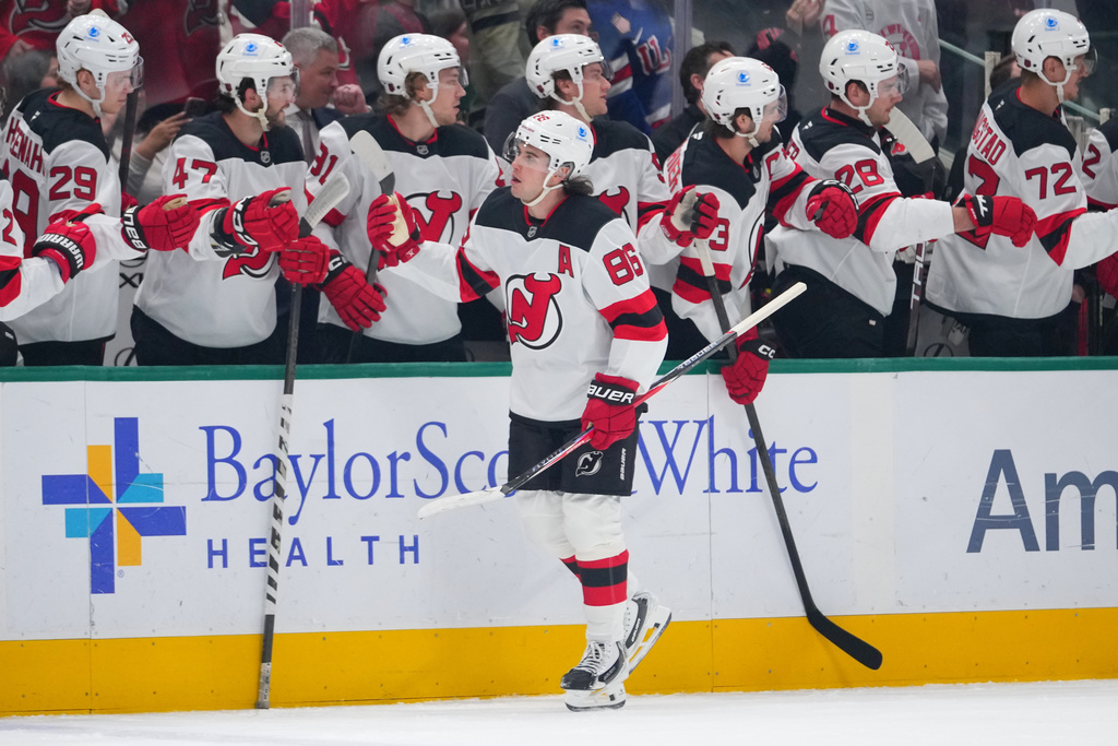 New Jersey Devils center Jack Hughes skates by his bench after scoring his first of two first period goals against the Dallas Stars during an NHL hockey game Tuesday, March 24, 2026, in Dallas. (AP Photo/Julio Cortez)