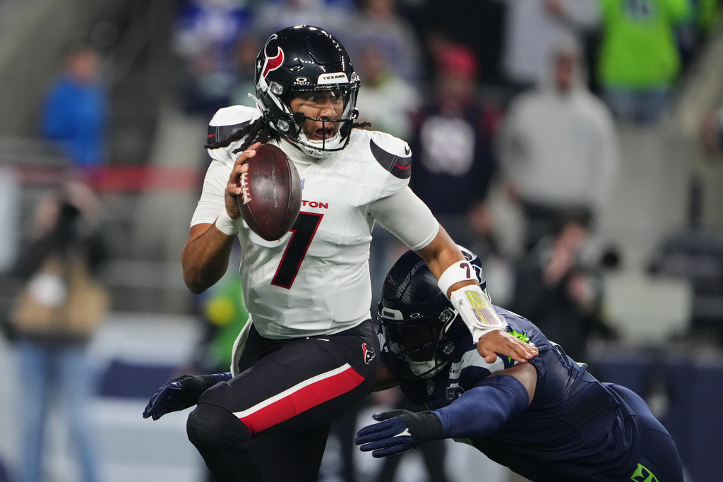 Houston Texans quarterback C.J. Stroud (7) is sacked by Seattle Seahawks linebacker Uchenna Nwosu, bottom, in the first half of an NFL football game Monday, Oct. 20, 2025, in Seattle. (AP Photo/Lindsey Wasson)