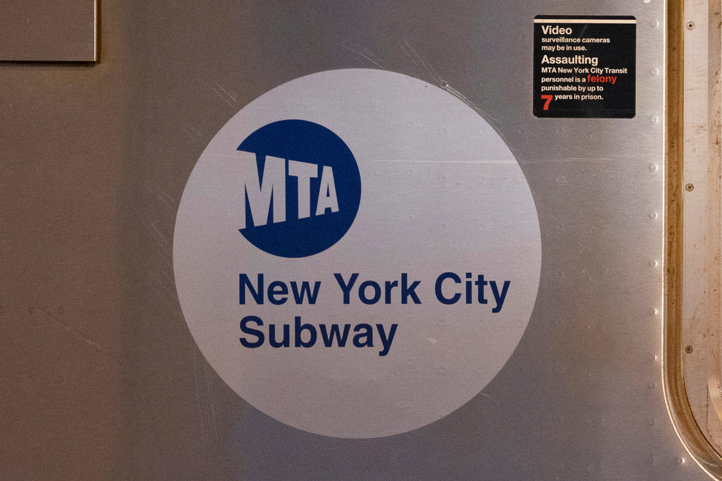 FILE - The MTA logo is seen on the side of a New York City subway car, April 23, 2020, in the Queens borough of New York. (AP Photo/Mark Lennihan, File)