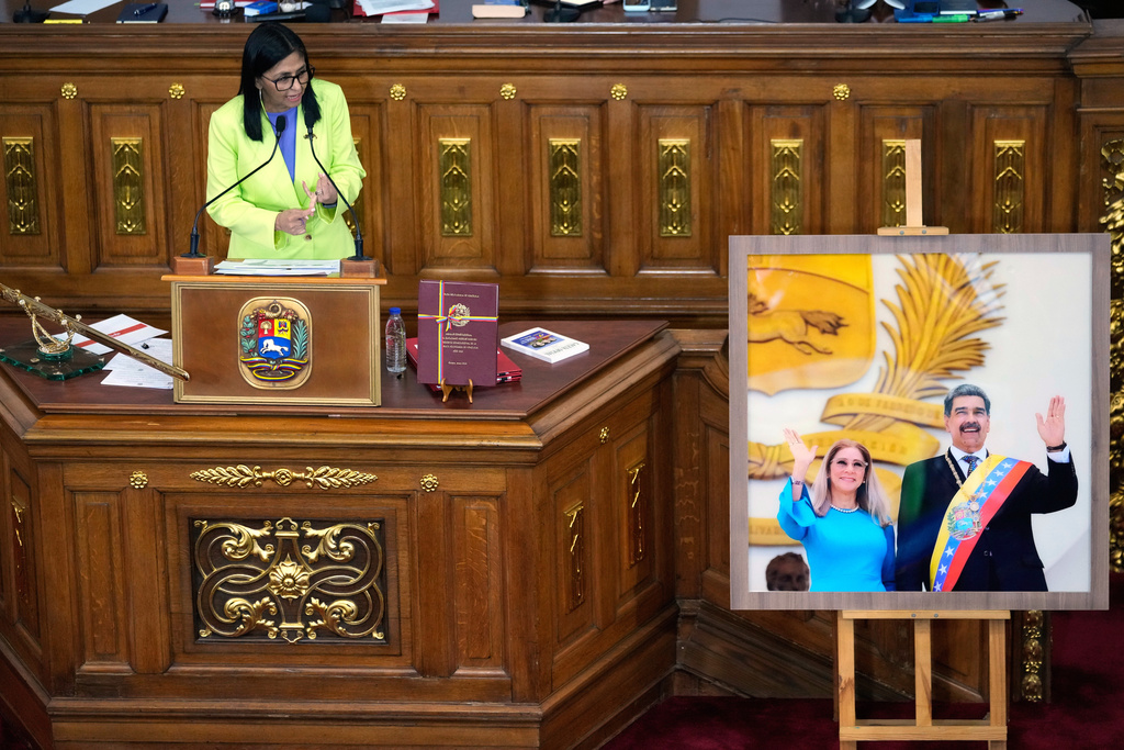 Venezuela's acting President Delcy Rodriguez addresses lawmakers next to a picture of former President Nicolas Maduro and his wife Cilia Flores, at the National Assembly in Caracas, Venezuela, Thursday, Jan. 15, 2026. (AP Photo/Ariana Cubillos)