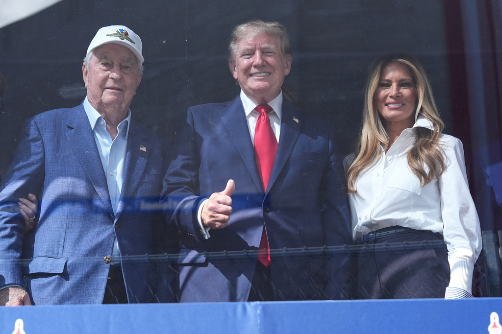 Roger Penske, President Donald Trump and first lady Melania Trump watch after Kyle Kirkwood (27) won the IndyCar Freedom 250 Grand Prix auto race in Washington, Sunday, Aug. 23, 2026. (AP Photo/Alex Brandon)