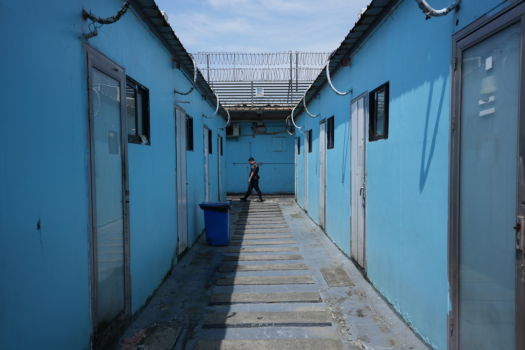 A security guard walks along living quarters for detainees at the Presidential Anti-Organized Crime Commission temporary detention center, a former scam compound, in Pasay, Philippines, Tuesday, Sept. 1, 2026. (AP Photo/Aaron Favila)