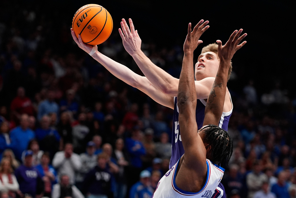 TCU guard Tanner Toolson shoots over Kansas guard Elmarko Jackson during overtime of an NCAA college basketball game Tuesday, Jan. 6, 2026, in Lawrence, Kan. (AP Photo/Charlie Riedel)