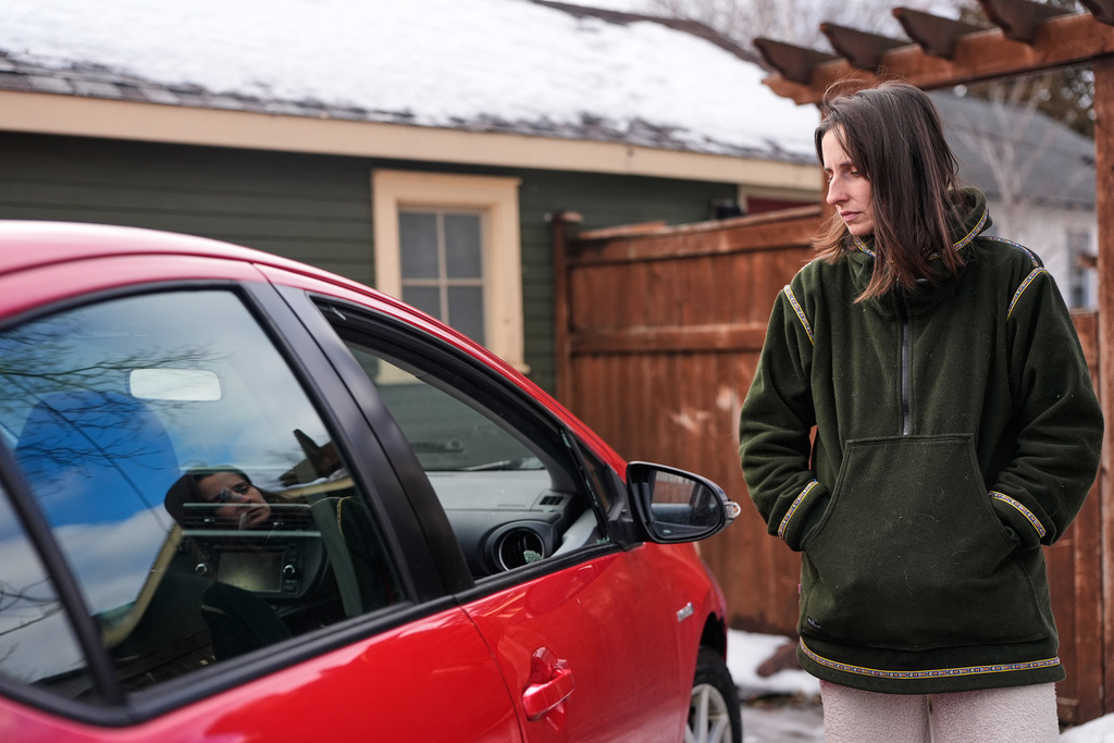 Patty O'Keefe, a U.S. citizens who was arrested while following federal agents' vehicles and briefly held at a federal facility in Minneapolis, stands next to her car showing that her front driver's side window was smashed in, Tuesday, Jan. 13, 2026. (AP Photo/Jen Golbeck)