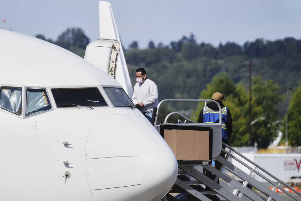 A detainee boards a U.S. Immigration and Customs Enforcement flight departing from King County International Airport-Boeing Field, Tuesday, Aug. 19, 2025, in Seattle. (AP Photo/Lindsey Wasson)