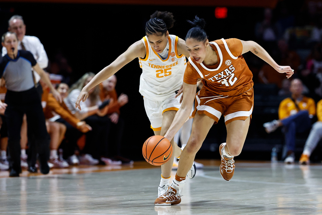 Texas forward Teya Sidberry (32) battles for the ball with Tennessee guard Deniya Prawl (25) during the first half of an NCAA college basketball game in Knoxville, Tenn., Sunday, Feb. 15, 2026. (AP Photo/Wade Payne)