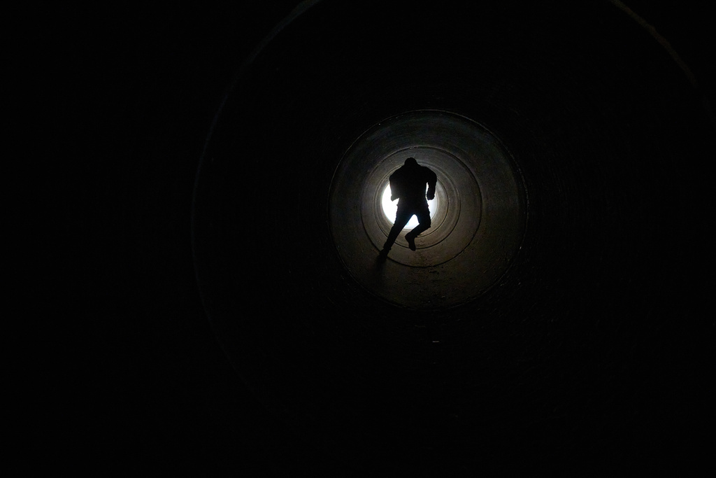 A boy runs inside cement pipe turned into a bomb shelter as air raid sirens warn of incoming Iranian missile strike in Michmoret, Israel, Tuesday, March 10, 2026. (AP Photo/Ariel Schalit)
