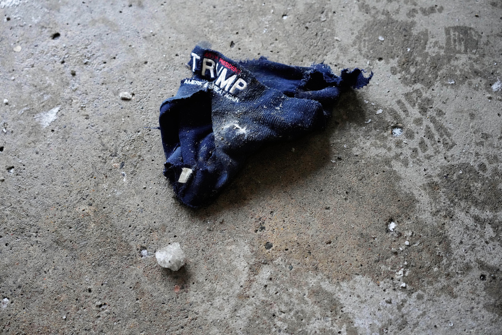 A ripped Trump hat lies on the ground of a parking garage Saturday, Jan. 17, 2026, in Minneapolis. (AP Photo/Yuki Iwamura)
