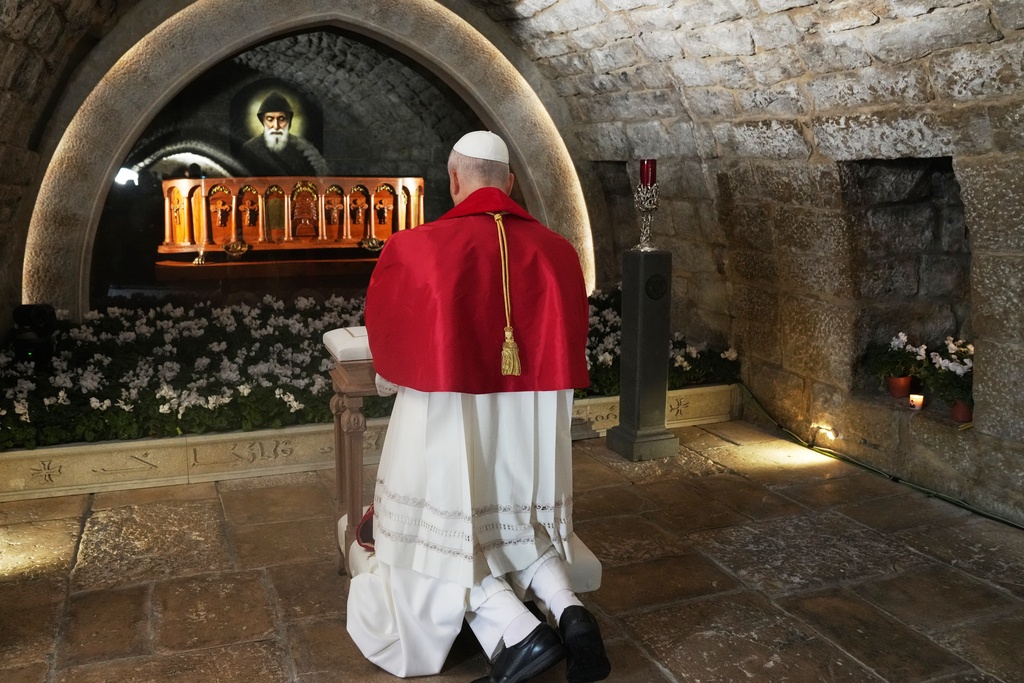 Pope Leo XIV prays in front of the tomb of Saint Charbel Makhlouf at the Monastery of Saint Maroun, in Annaya, Lebanon, Monday, Dec. 1, 2025. (AP Photo/Domenico Stinellis, Pool)