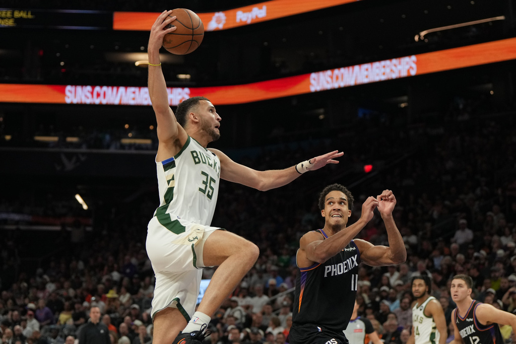 Milwaukee Bucks forward Pete Nance (35) shoots over Phoenix Suns forward Oso Ighodaro during the first half of an NBA basketball game, Saturday, March 21, 2026, in Phoenix. (AP Photo/Rick Scuteri)