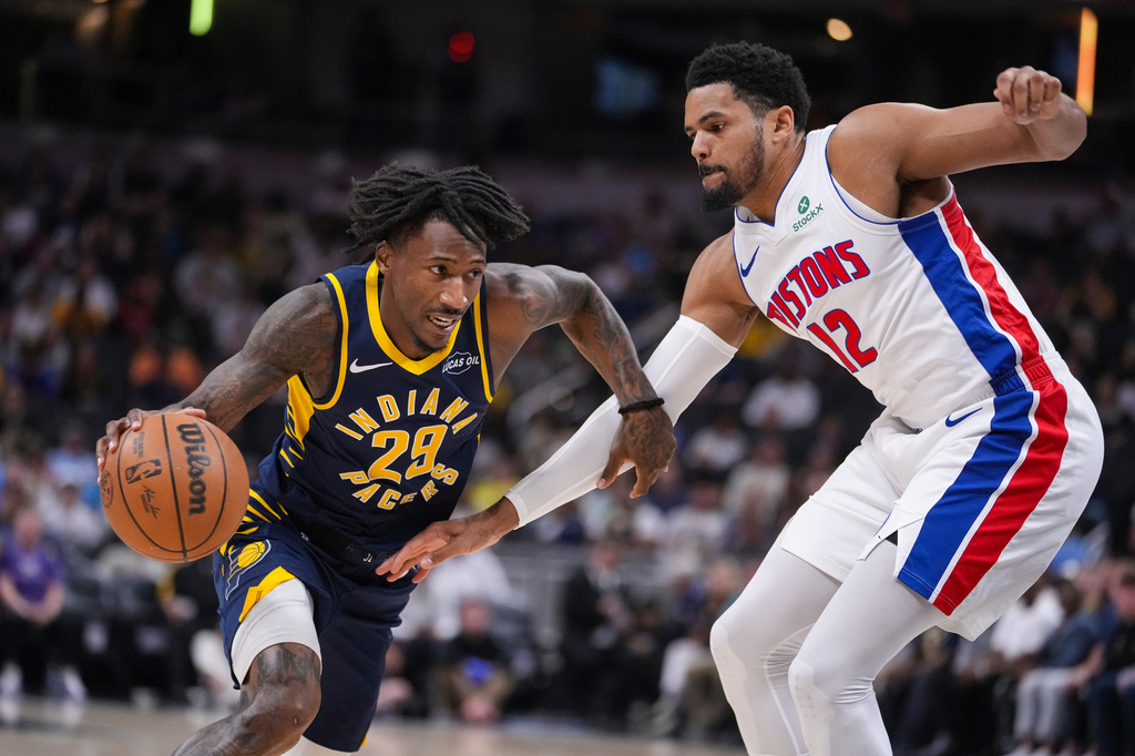 Indiana Pacers guard Quenton Jackson (29) drives on Detroit Pistons forward Tobias Harris (12) during the first half of an NBA basketball game in Indianapolis, Sunday, April 12, 2026. (AP Photo/Michael Conroy)