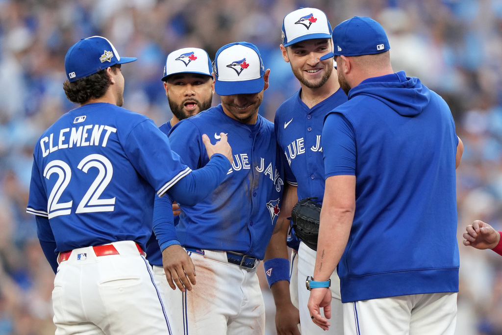Toronto Blue Jays pitcher Trey Yesavage, second from right, celebrates with teammates after being pulled from the mound by manager John Schneider, right, during the sixth inning of Game 2 of baseball's American League Division Series against the New York Yankees in Toronto, Sunday, Oct. 5, 2025. (Nathan Denette/The Canadian Press via AP)