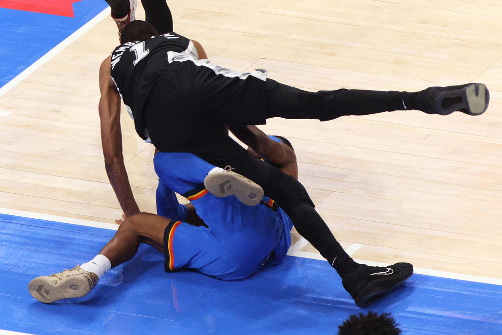 San Antonio Spurs forward Victor Wembanyama (1) falls on Oklahoma City Thunder guard Shai Gilgeous-Alexander (2) during the second half of Game 1 in a third-round NBA basketball playoffs series Monday, May 18, 2026, in Oklahoma City. (AP Photo/Nate Billings)