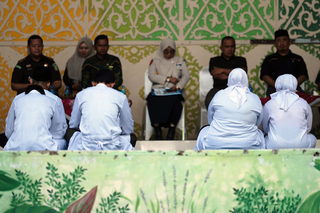 People convicted of violating Islamic law, among them are an unmarried couple who were found gulty of kissing during a TikTok livestream, wait for their turn to be publicly caned in Banda Aceh, Indonesia, Thursday, July 2, 2026. (AP Photo/Reza Saifullah)