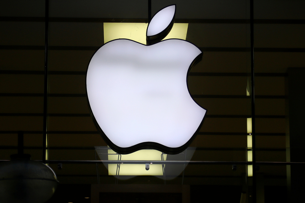 FILE - The logo of Apple is illuminated at a store in the city center in Munich, Germany, on Dec. 16, 2020. (AP Photo/Matthias Schrader, File)