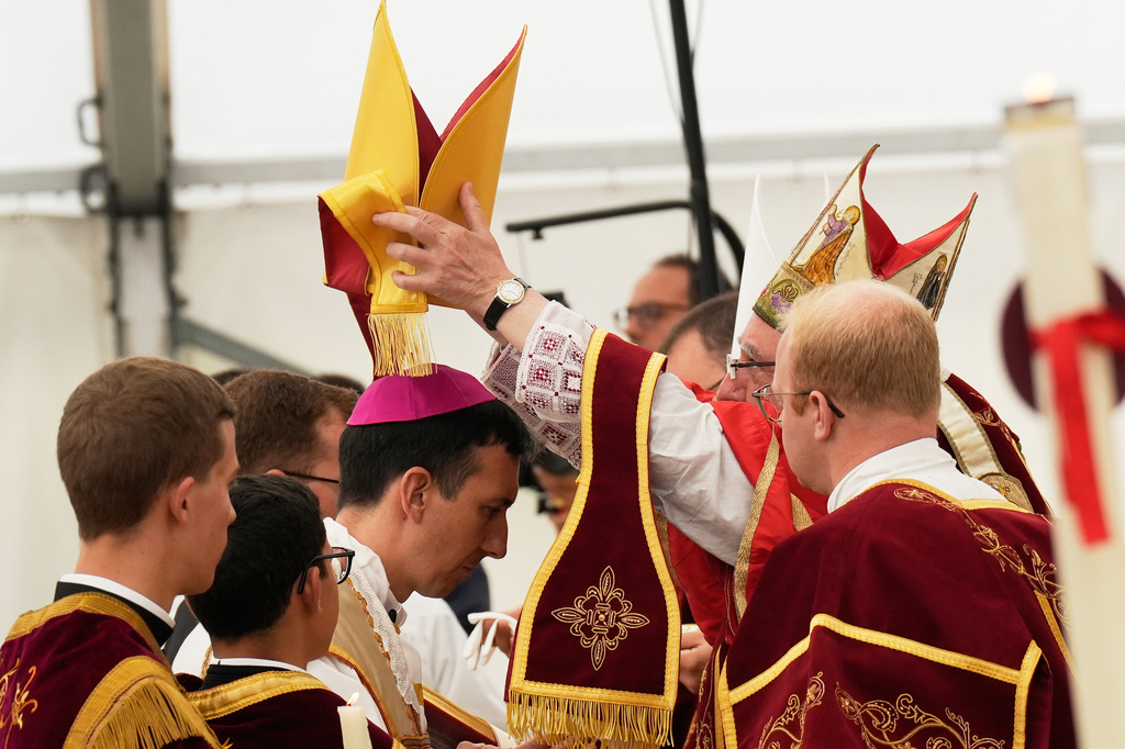 Newly consecrated bishop Michel Poinsinet de Sivry receives the miter from Bishop Alfonso de Galarreta during a ceremony in a tent set up outside the Society of St. Pius X seminary in Econe, Switzerland, Wednesday, July 1, 2026. (AP Photo/Baz Ratner)