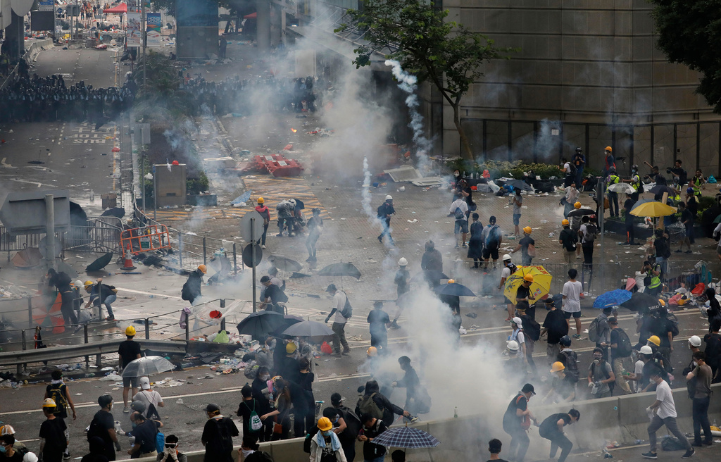 FILE - Riot police work to disperse protesters with fire tear gas outside the Legislative Council June 12, 2019, in Hong Kong. (AP Photo/Vincent Yu, File)