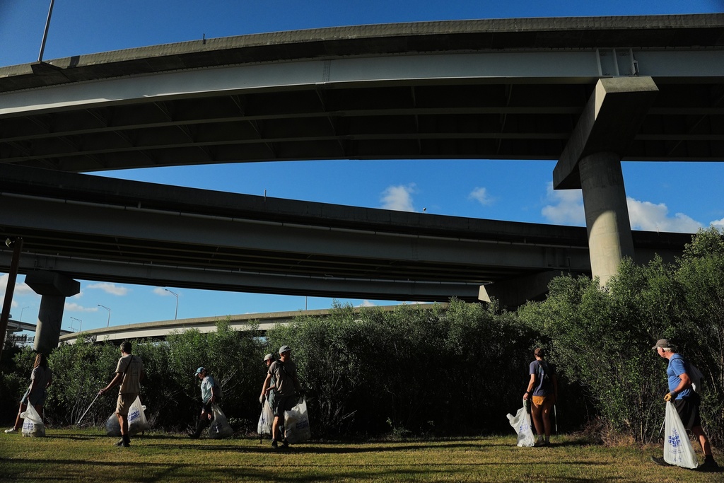 Volunteers clean up trash near an overpass, Monday, Oct. 6, 2025, in Charleston, S.C. (AP Photo/Joshua A. Bickel)